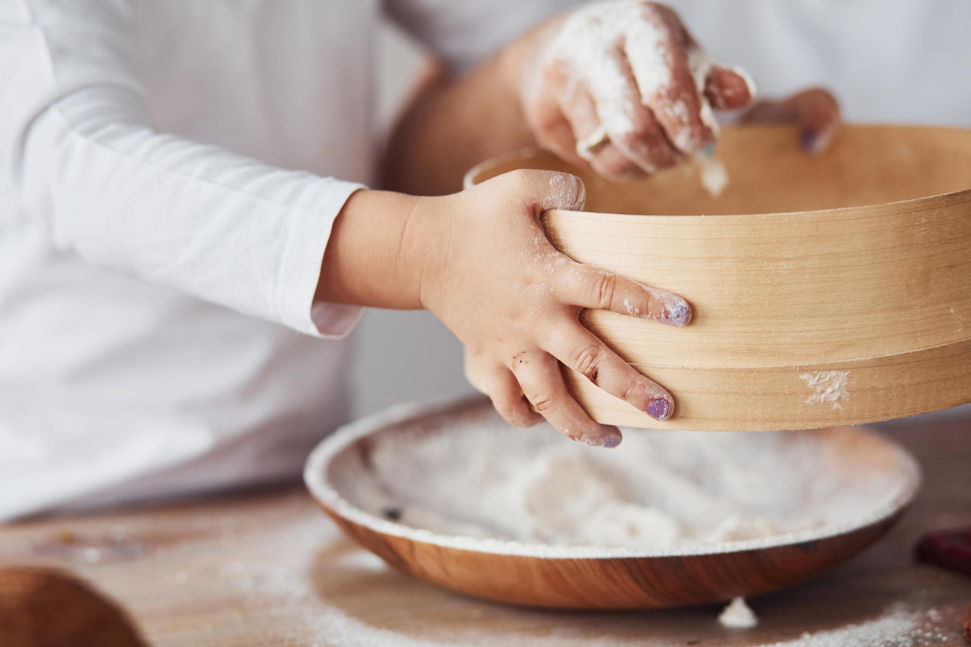 Hands kneading dough in a bowl